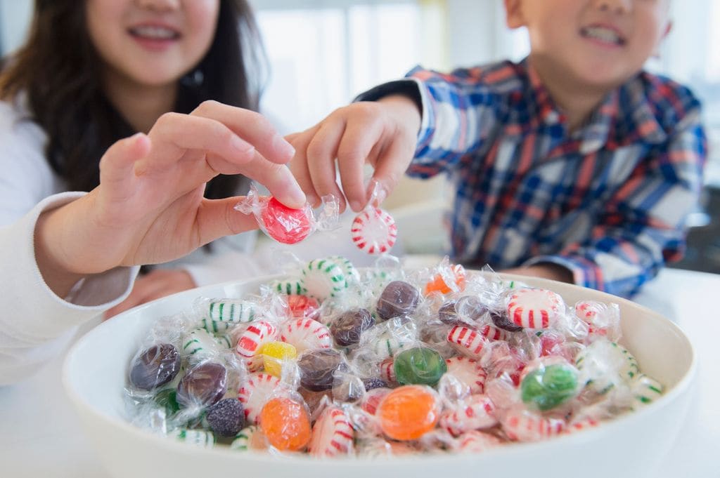 dos niños con un bol de caramelos 