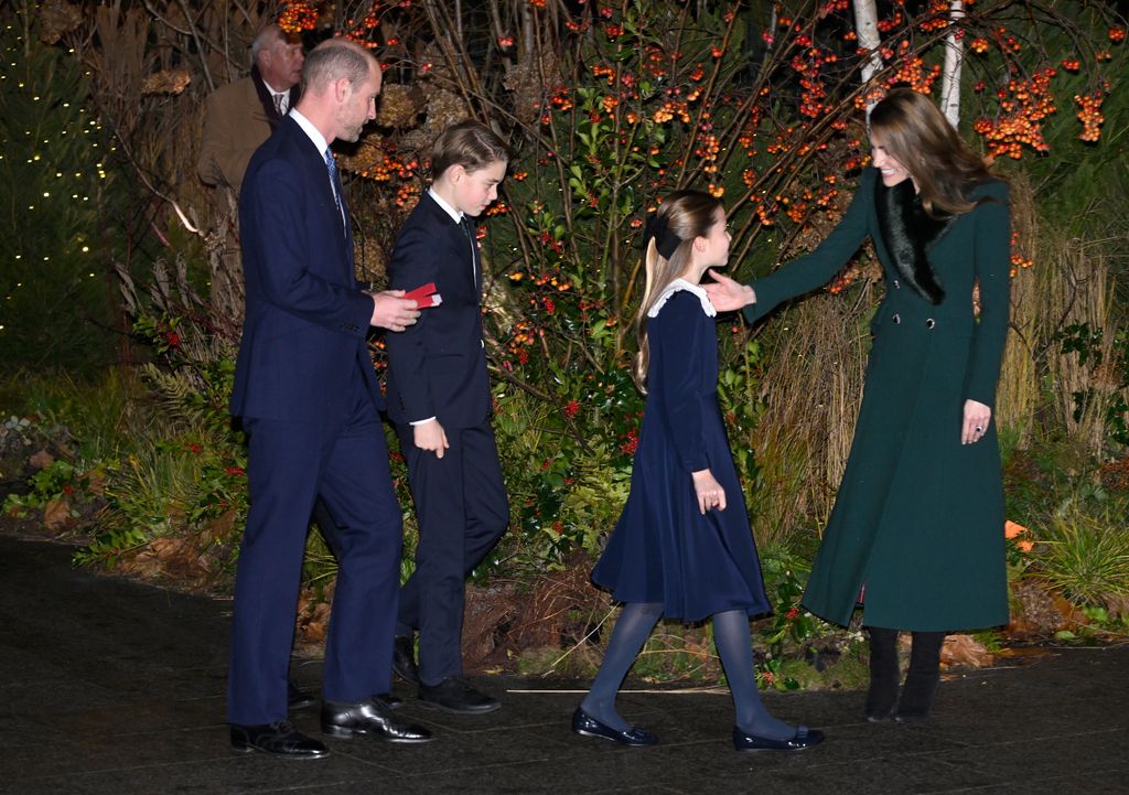 Catherine, Princesa de Gales, saluda al Príncipe Guillermo, Príncipe de Gales (izq.), al Príncipe Jorge de Gales y a la Princesa Carlota de Gales mientras asisten al servicio de villancicos 'Juntos en Navidad' en la Abadía de Westminster.