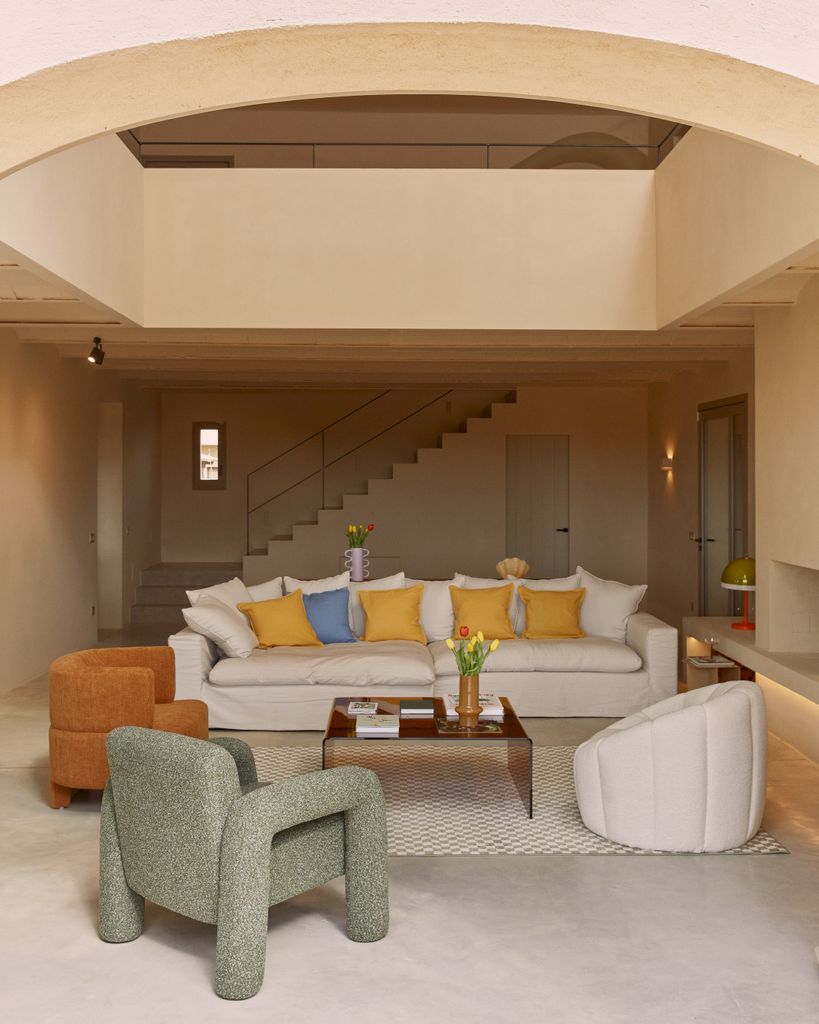 Salón con sofá blanco y butacas de colores diferentes