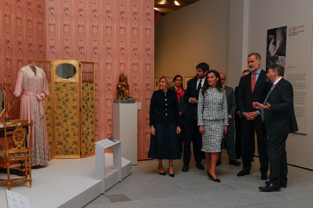 Don Felipe y doña Letizia observando una bata de la reina Victoria Eugenia 