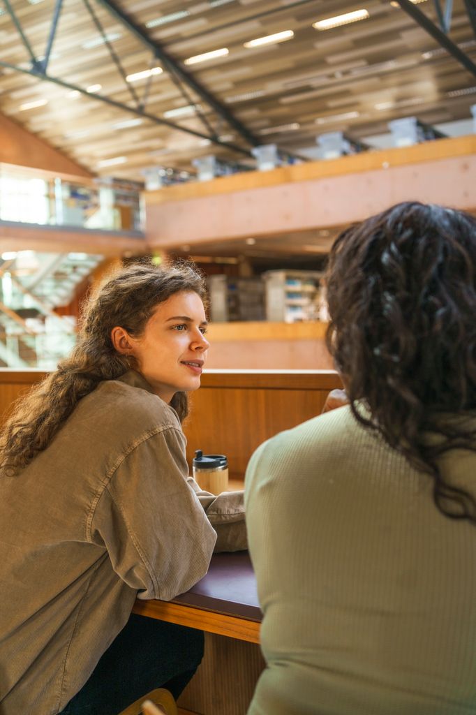 chicas hablando biblioteca