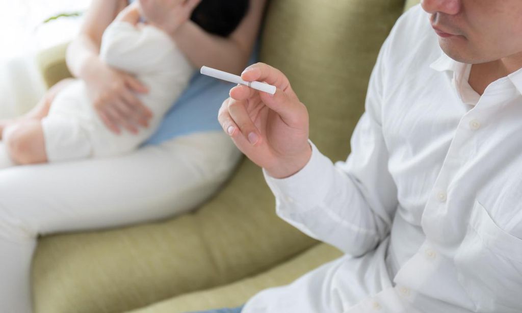 padre fumando delante de su familia