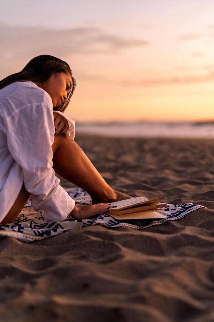 chica leyendo playa