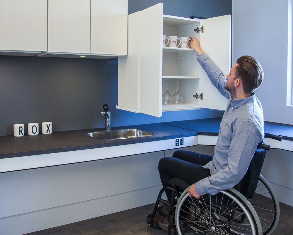 Usuario en silla de ruedas en una cocina adaptada a sus necesidades