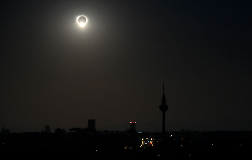 El cielo se oscurece sobre Madrid mientras el efecto del anillo de diamantes brilla sobre la silueta del Pirulí.