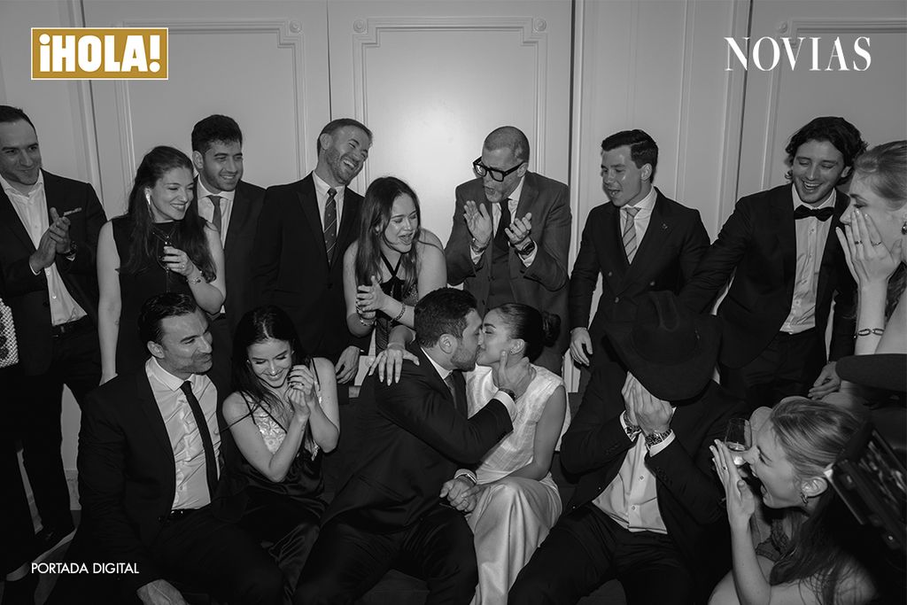 Ale Capetillo y Nader Azar se besan rodeados de amigos que celebran con aplausos y sonrisas durante su boda civil en Madrid. Foto: Virginia Hernandez/Click10 | Vestido: Lorena Formoso | Make Up: Sisley | Joyas: Rabat | Zapatos: Jimmy Choo | Locación: Four Seasons Hotel Madrid