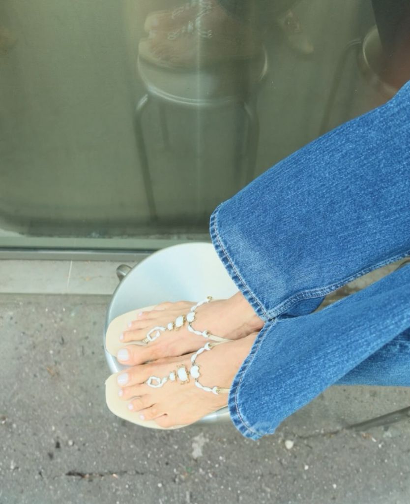 Adriana Abascal, con vaqueros, camisa de manga larga y sandalias en verano.