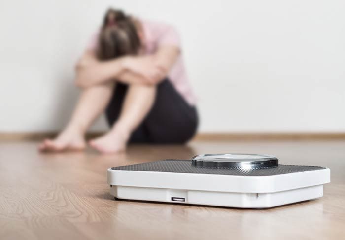 mujer decepcionada ante la báscula