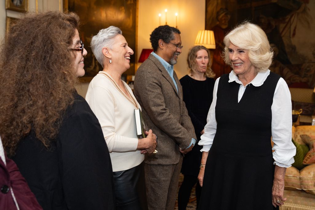 Plano medio de la reina Camilla saludando a varios escritores en un evento 