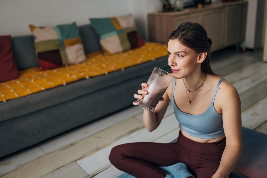 mujer bebiendo un batido después de hacer deporte