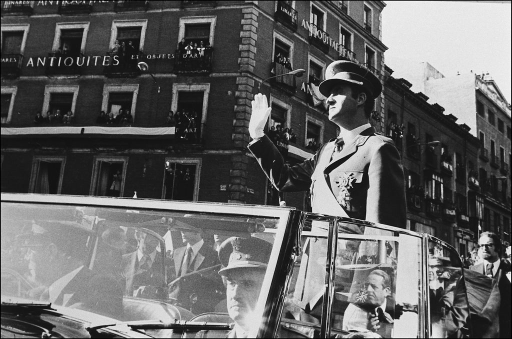 Juan Carlos I, de pie en el vehículo oficial conducido por su chófer, el día que fue proclamado Rey de España el 22 de noviembre de 1975