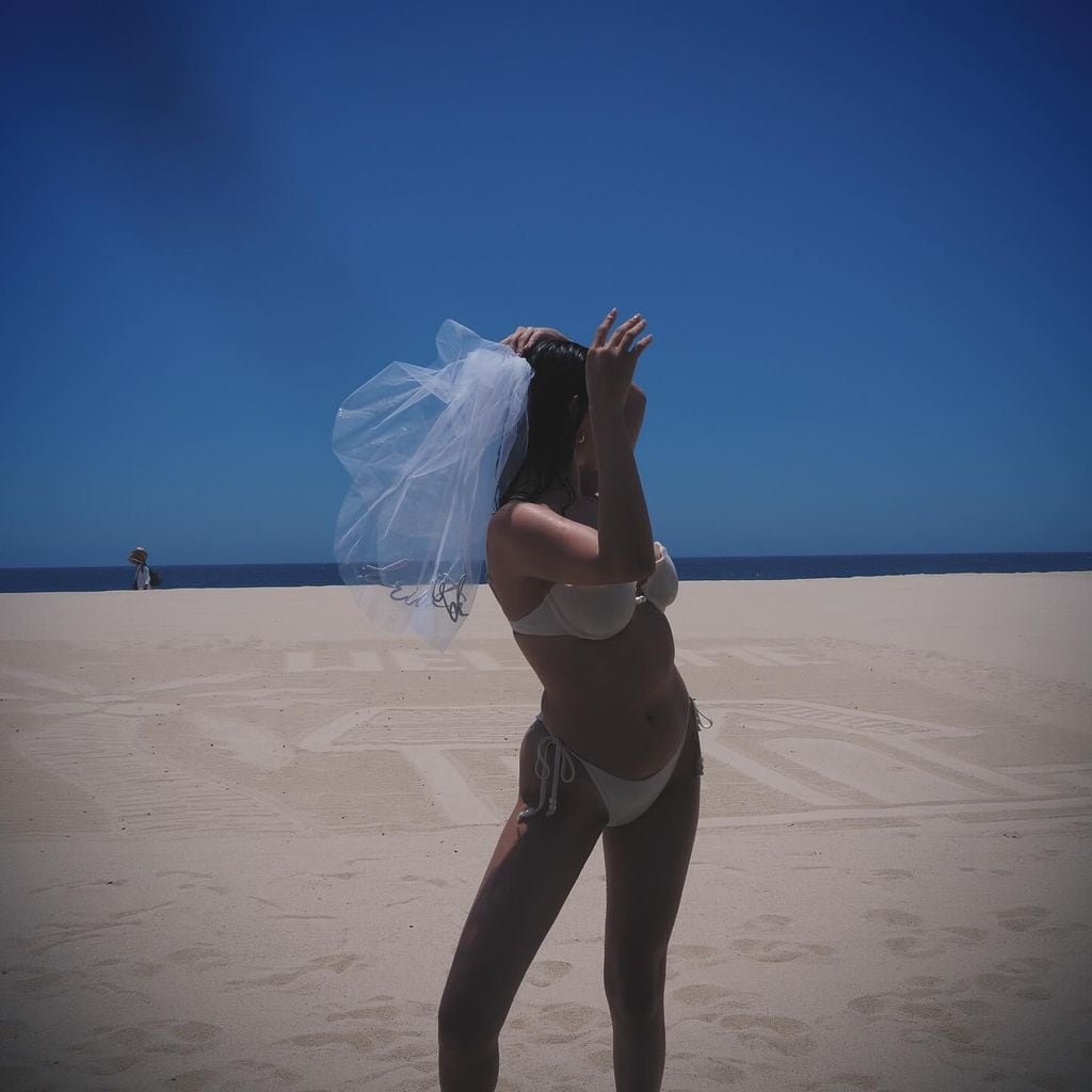Selena Gomez llevó la temática de 'bride to be' hasta la playa con un bikini blanco y velo a juego.