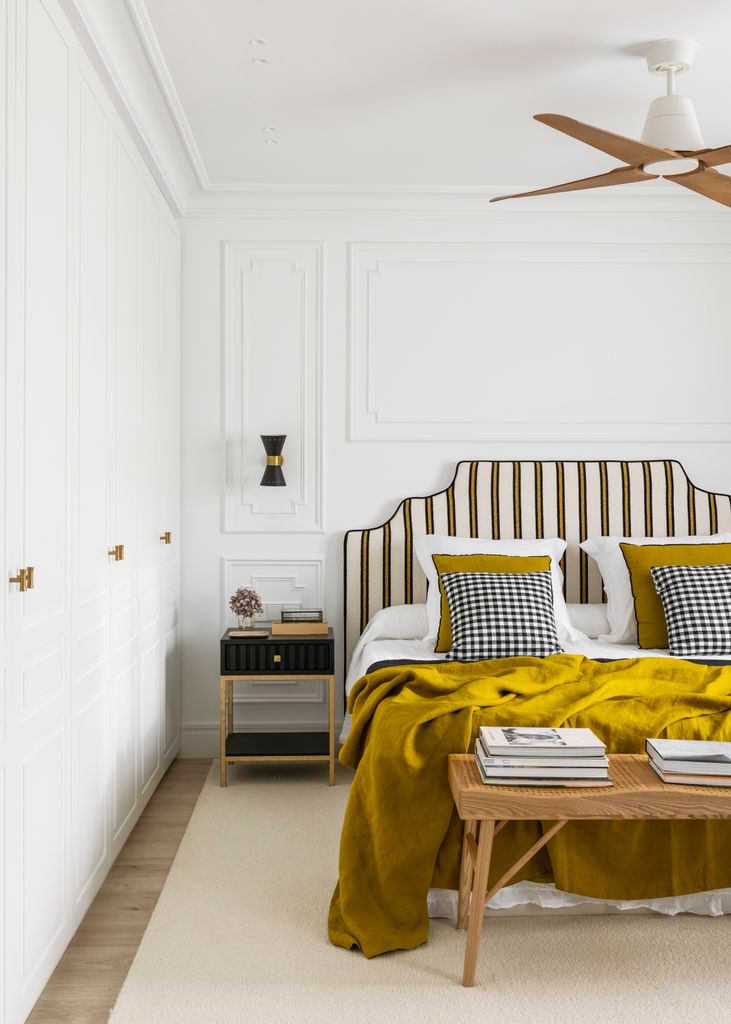 Dormitorio con ventilador de techo en blanco y madera