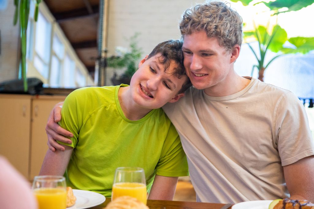 Hermanos, uno de ellos con discapacidad, tomando un zumo