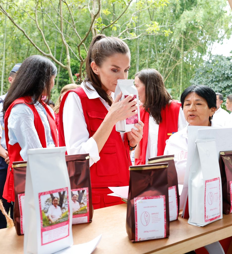 La Reina, en Cartagena de Indias, durante una visita a la Fundación AECID, oliendo un café local.