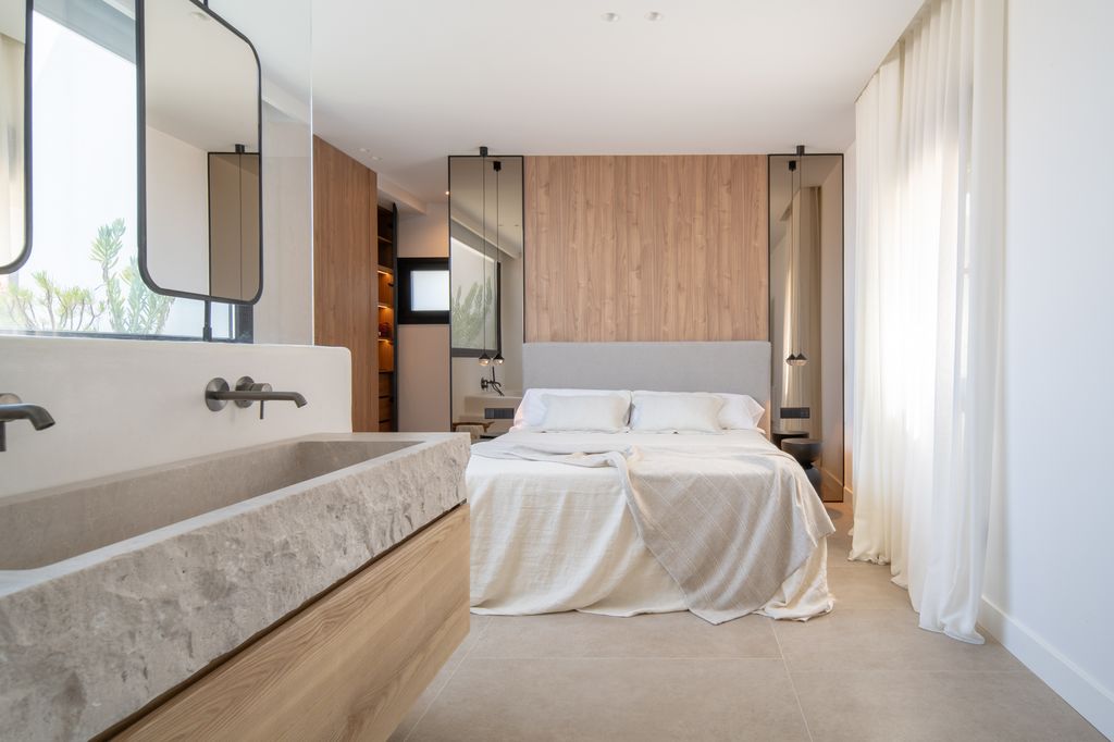 Dormitorio con cama con pared de madera y espejos