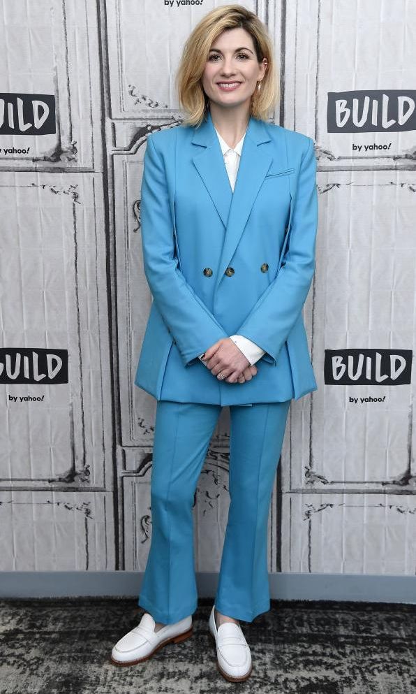 jodie whittaker con traje sastre azul claro y mocasines blancos de cuero