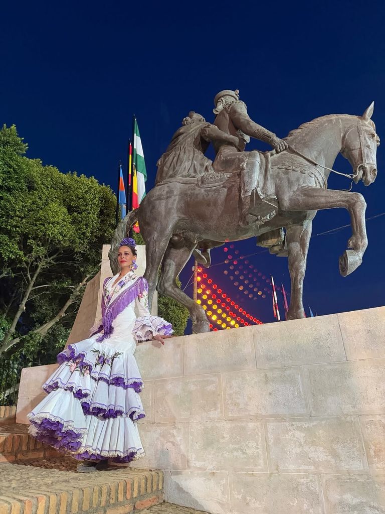 Eva González con unvestido de flameca blanco y morado de Pilar Vera en la Feria de Mairena del Alcor