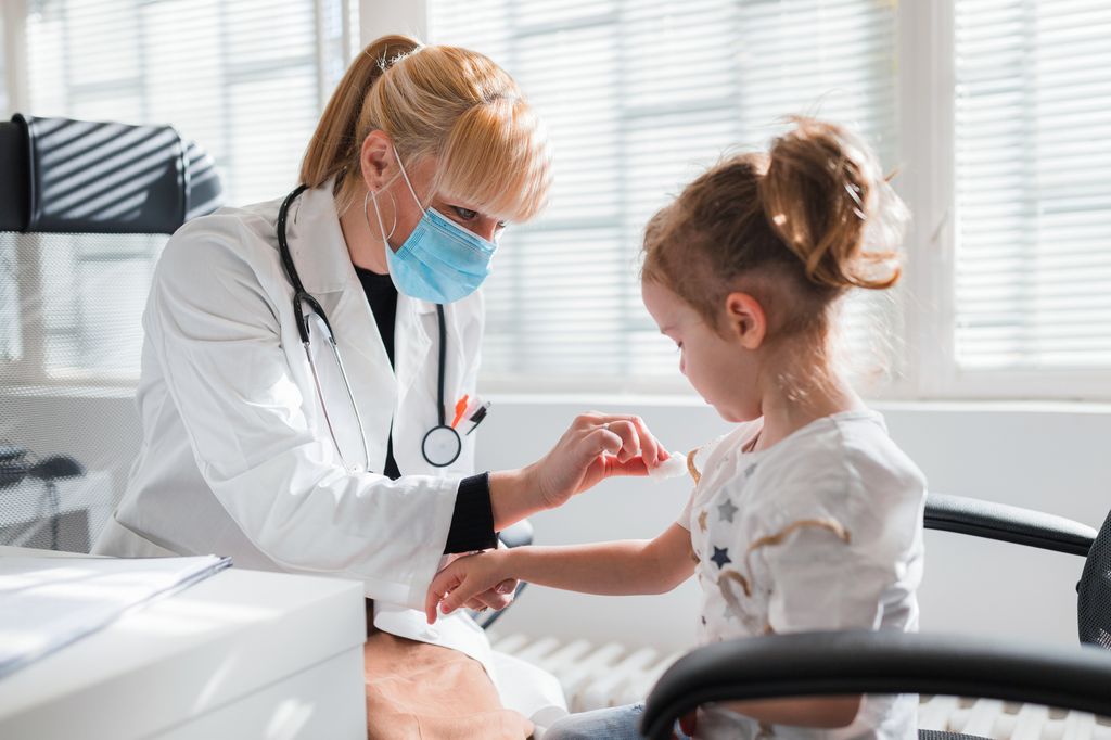 enfermera haciendo una analítica de sangre a una niña