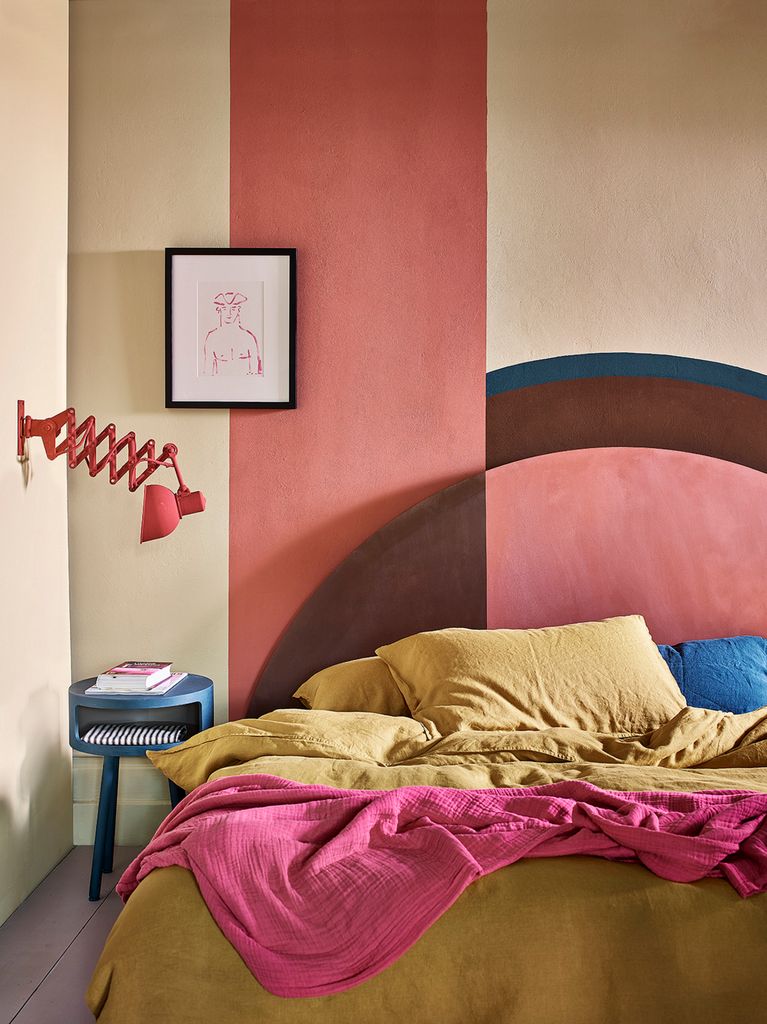 Pared del cabecero con motivos geométricos en rosa y marrón