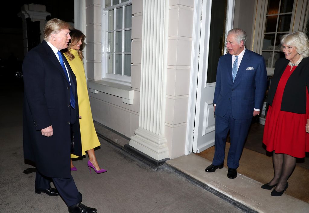 Plano medio de Donald y Melania Trump llegando a un evento con Carlos III y Camilla de Inglaterra
