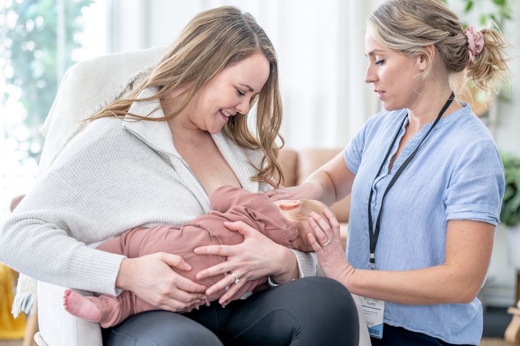 Madre dando el pecho con ayuda de asesora de lactancia