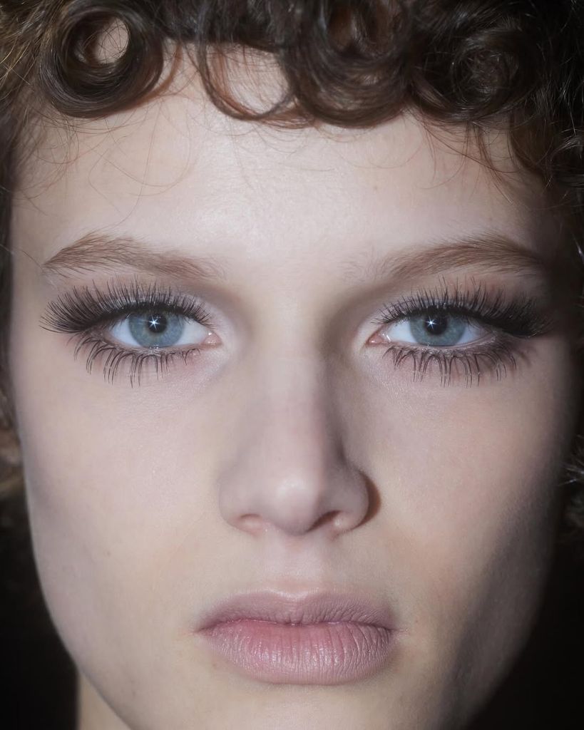 Las pestañas son las protagonistas del maquillaje, el resto del mismo es bastante pálido. 