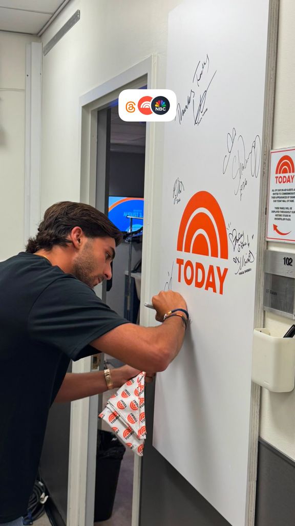 El futbolista, firmando en el muro de autógrafos