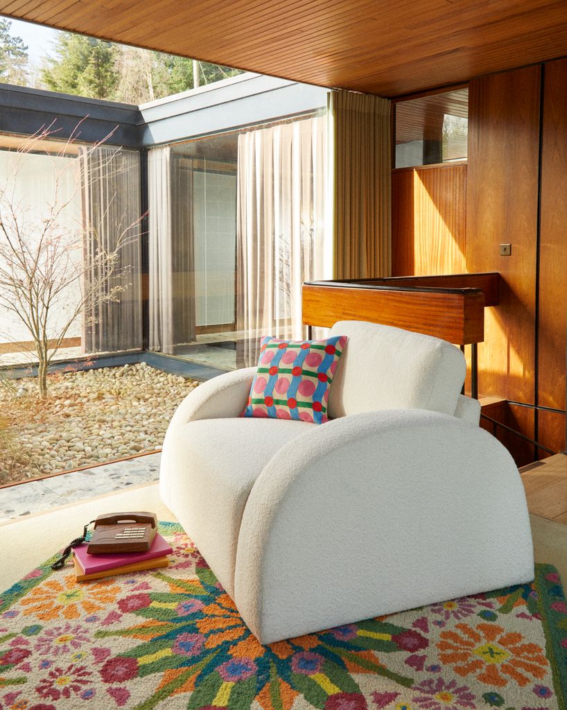 Sillón de borreguito con cojín y alfombra de colores