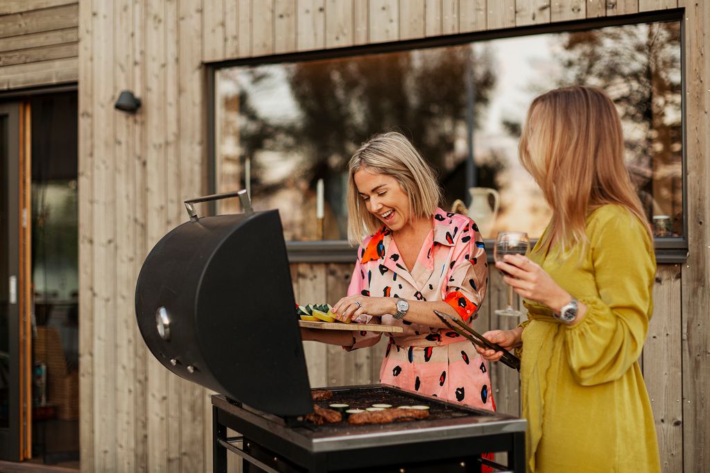 dos amigas haciendo una barbacoa en el patio de la casa