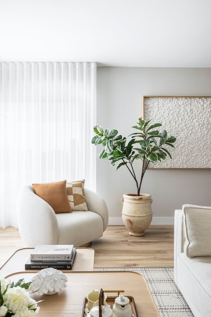 Salón con butaca y planta grande. 