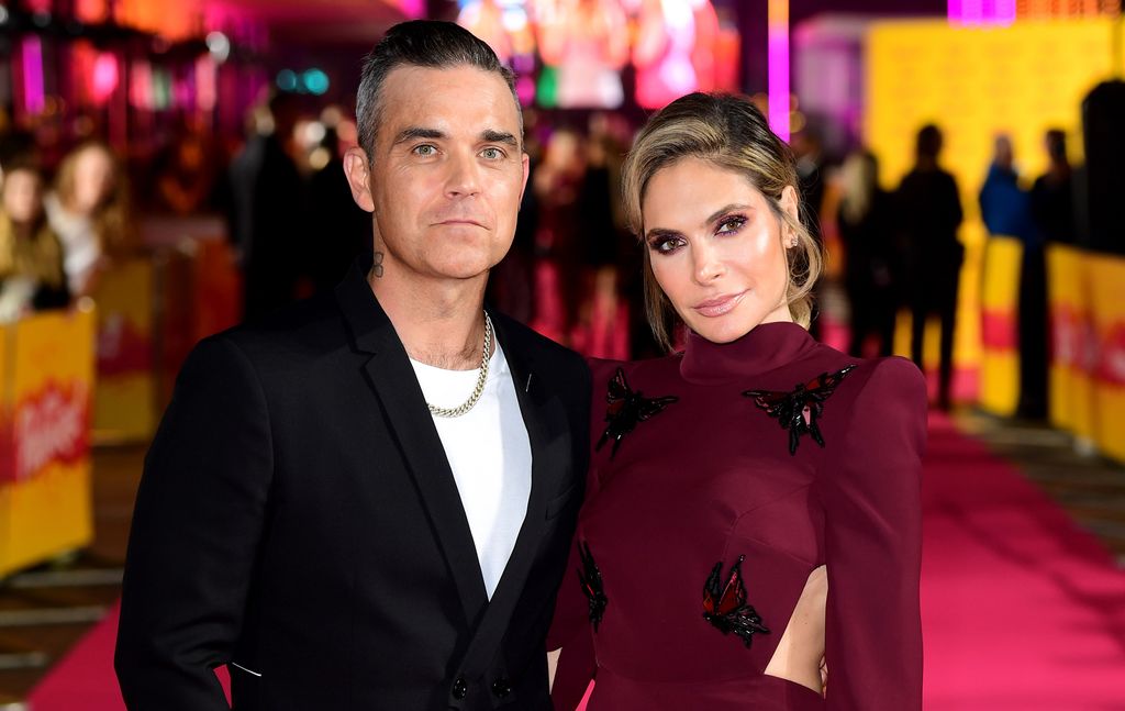 Plano medio de Robbie Williams y Ayda Field en un evento