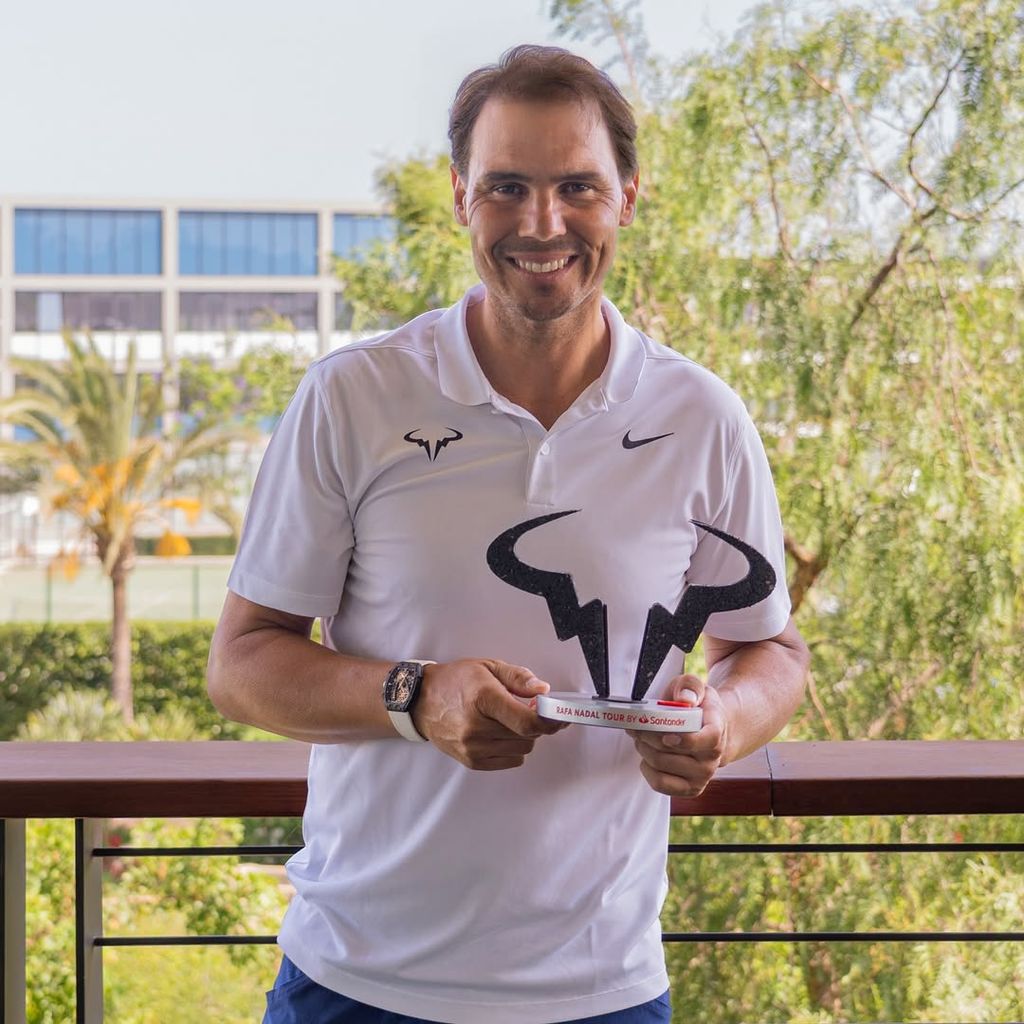 Rafa Nadal sostiene un trofeo con el logo de su marca