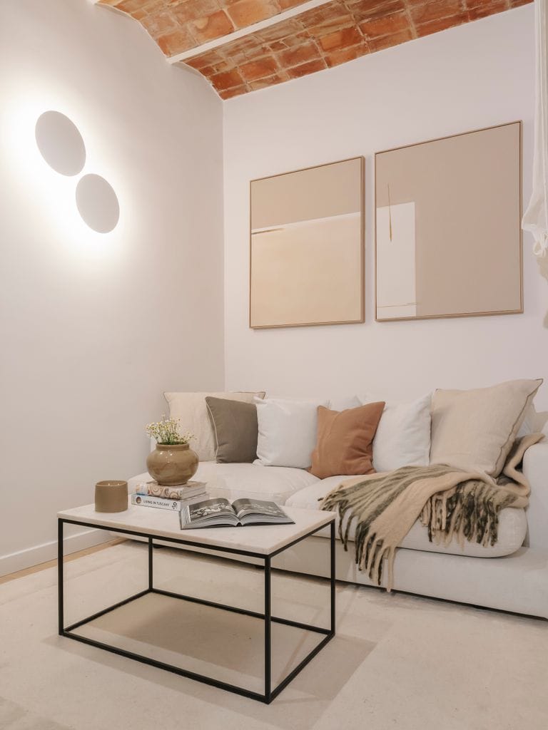 Salón con sofá, mesa de centro y apliques decorativos