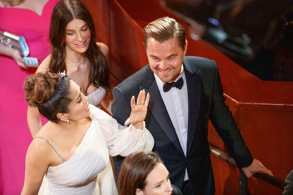 Plano medio de Leonardo DiCaprio con Salma Hayek y Camila Morrone