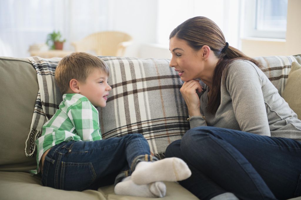 Madre hablando en el sofá con su hijo
