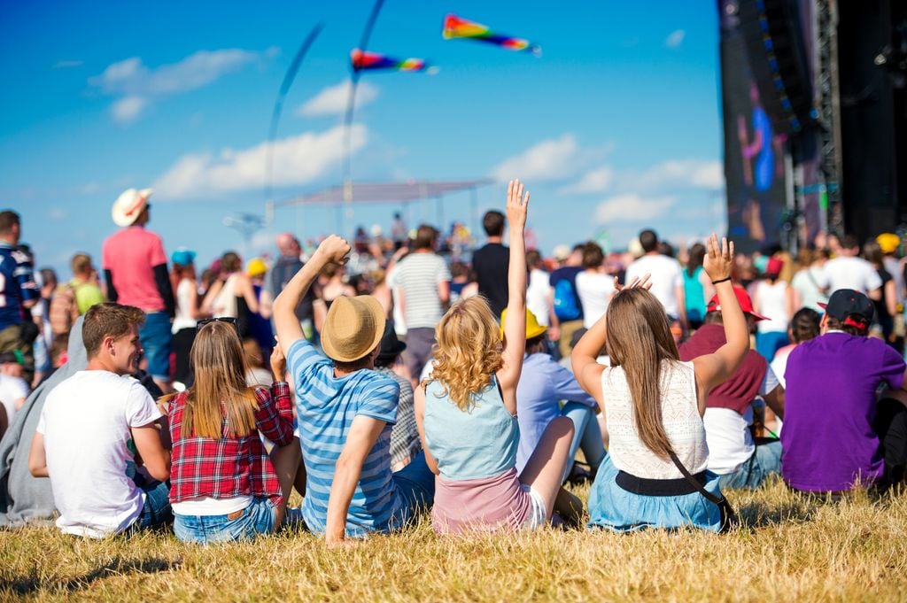 Grupo de adolescentes sentados en un festival de música al aire libre