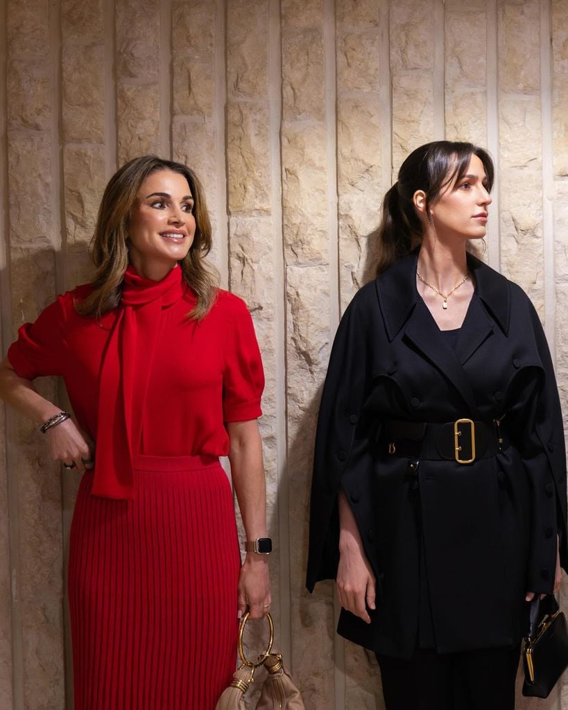 Plano medio de Rania de Jordania con la princesa Rajwa con looks rojo y negro