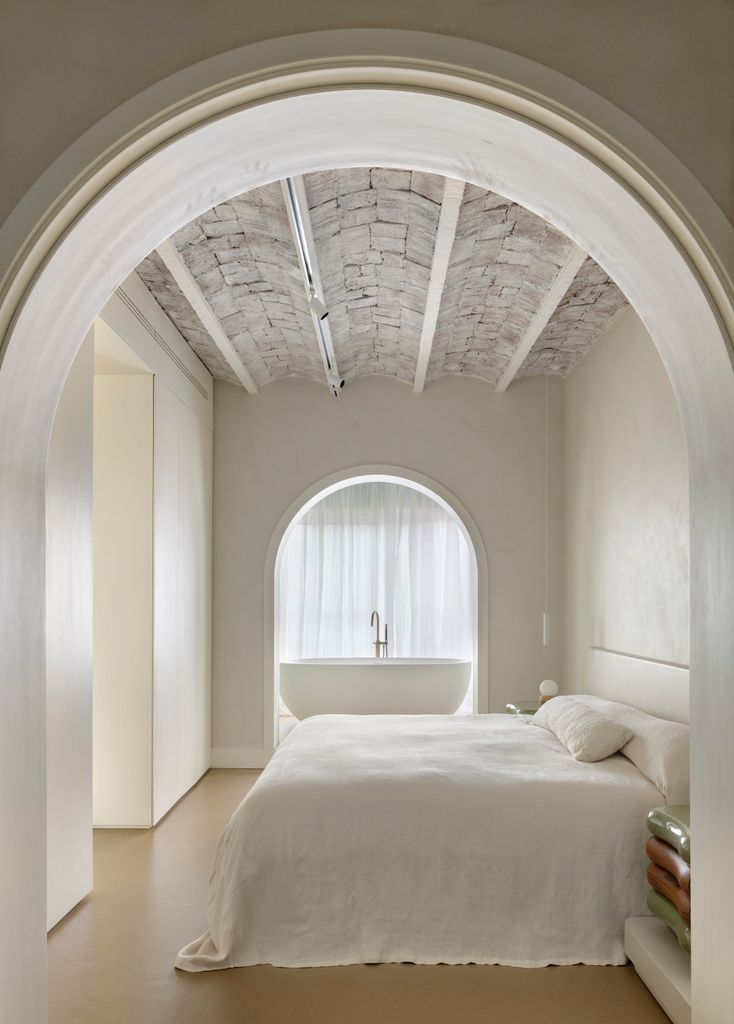 Vano en forma de arco entre dormitorio y baño
