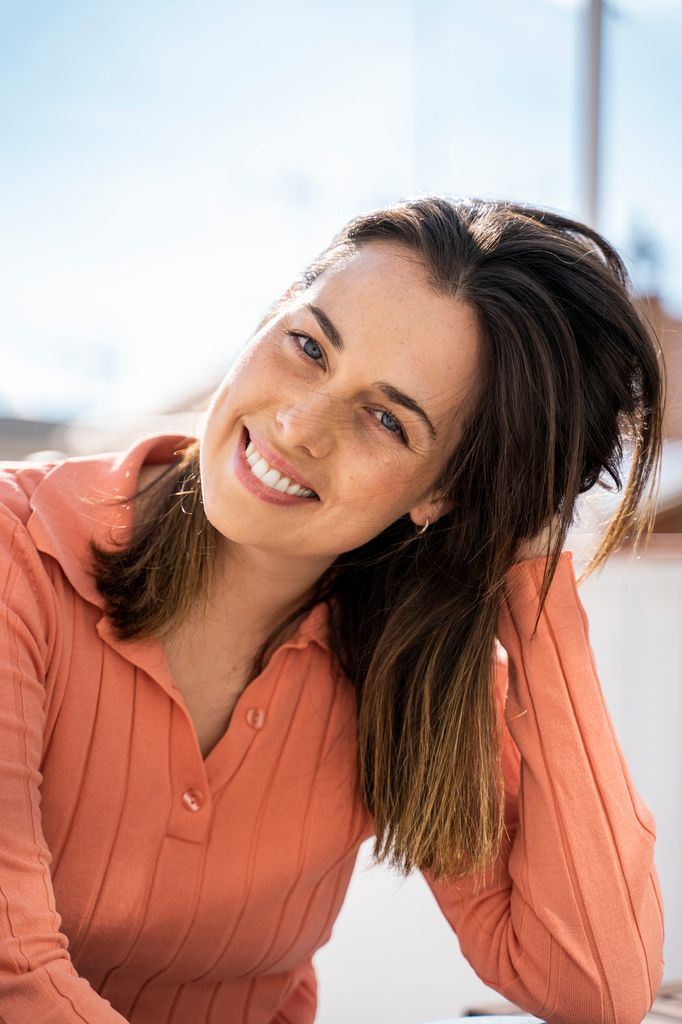 mujer sonriente tocándose el cabello