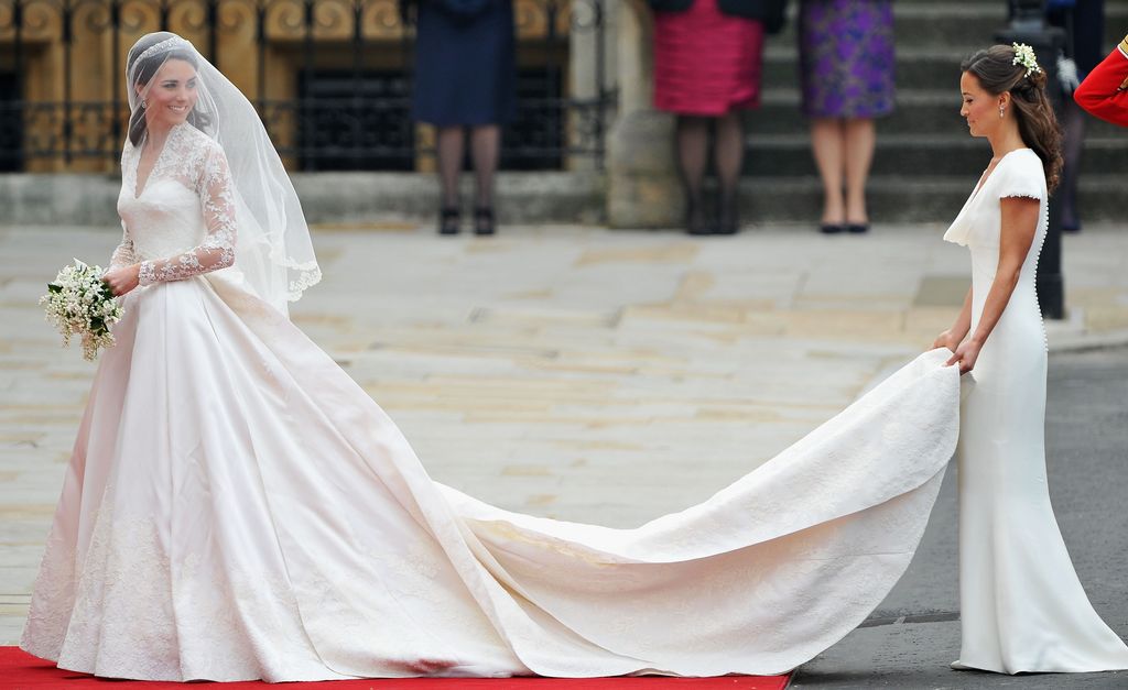 Kate Middleton entrando a su boda con su hermana sosteniendo su vestido