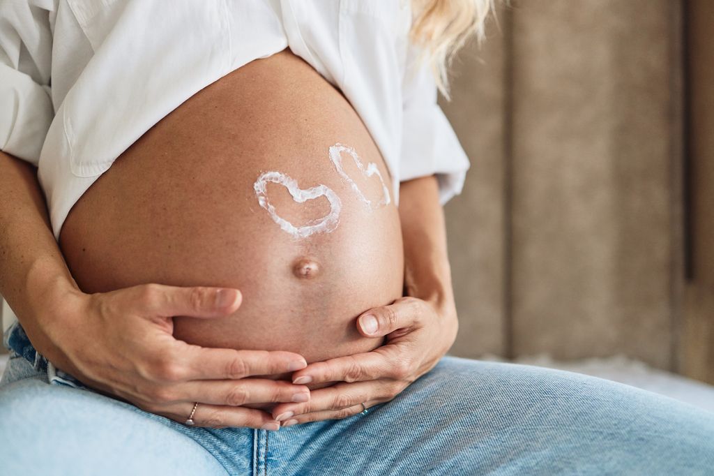 Barriga de embarazada con dos corazones pintados
