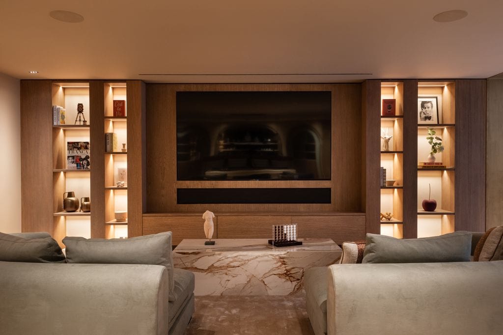 Sala de TV con mueble de madera y sofás blancos