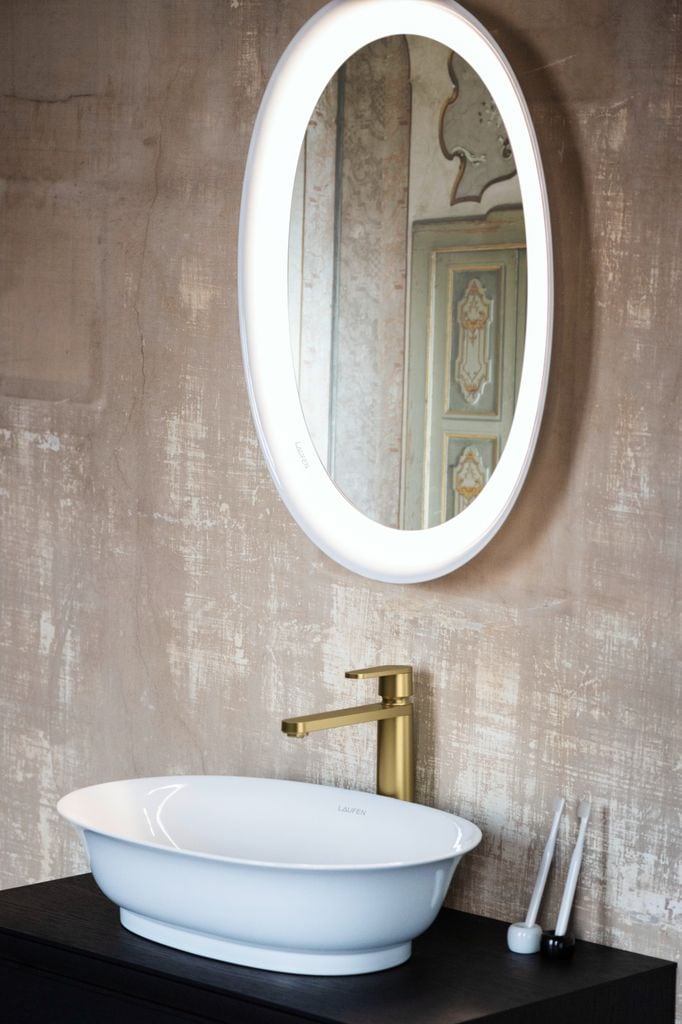 Lavabo con grifería dorada y espejo