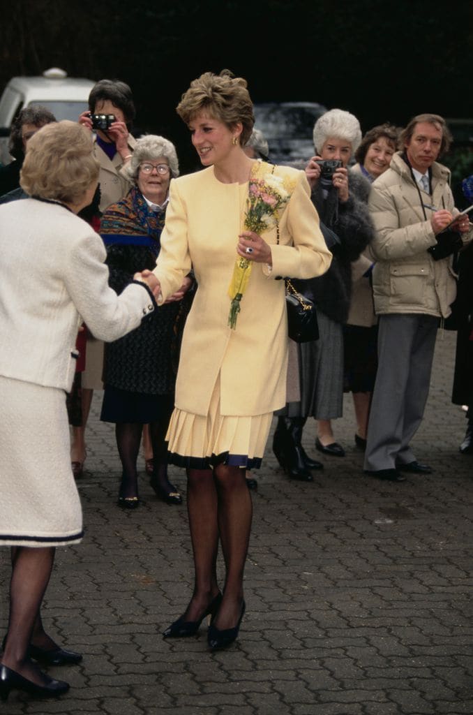 Diana en un conjunto amarillo por Catherine Walker y accesorios Chanel.