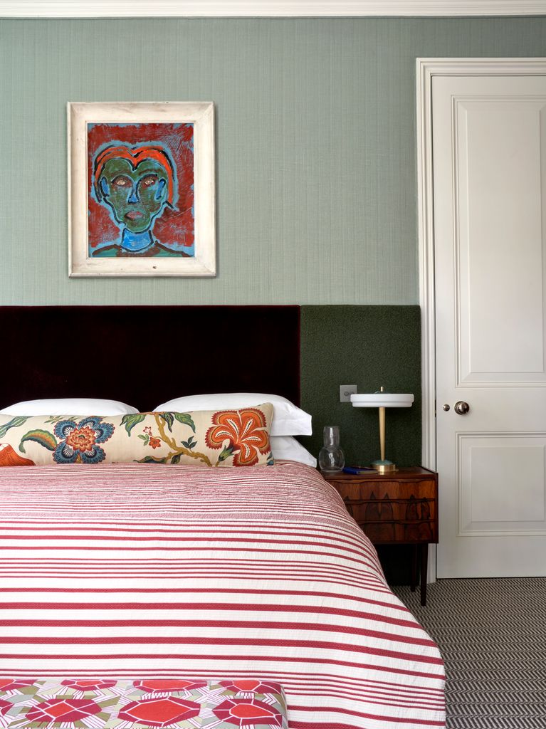 Dormitorio con pared verde y cocha a rayas blancas y rojas  