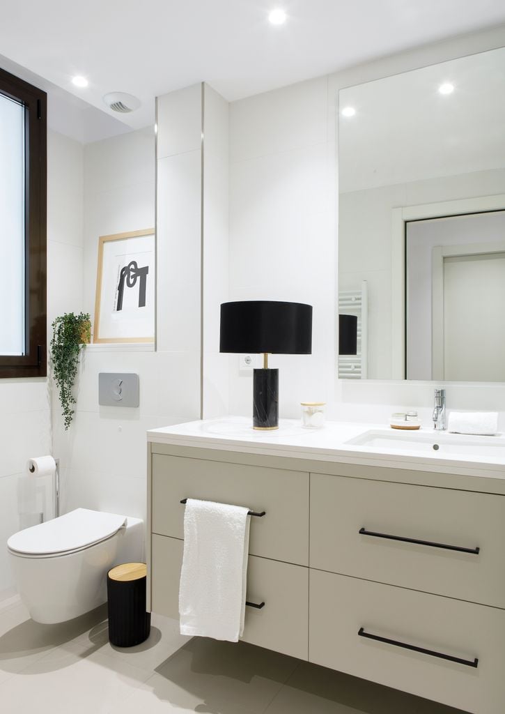 Baño con inodoro con cisterna empotrada.