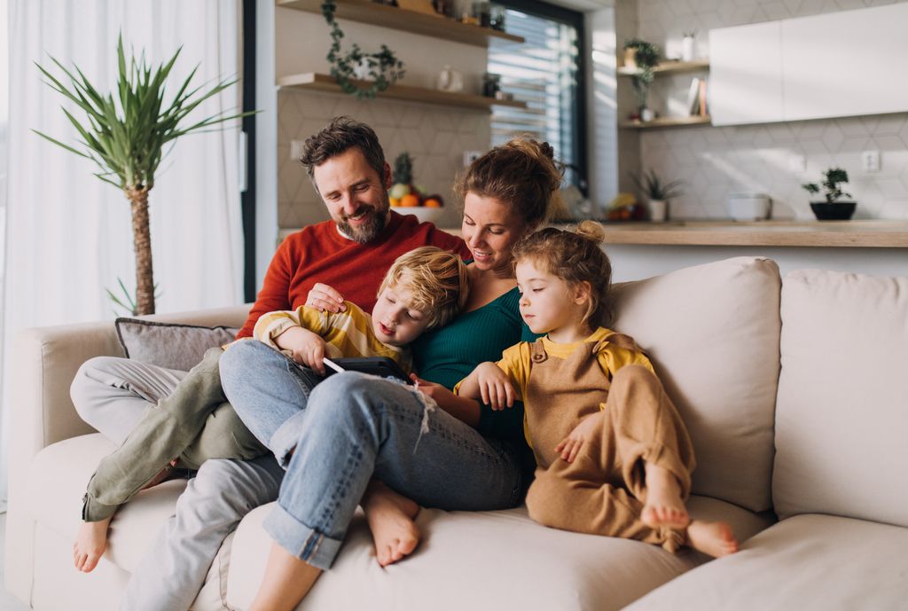 Familia feliz juntos en el sofá