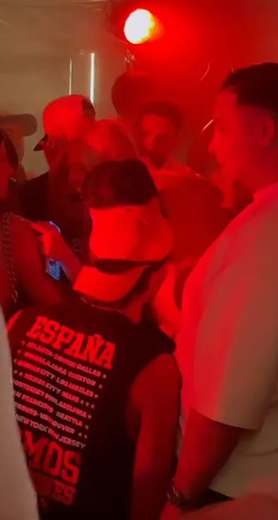 Imagen de la fiesta privada con Ferran Torres en primer término con la gorra y la camiseta de España y Ana Mena delante de él sonriendo