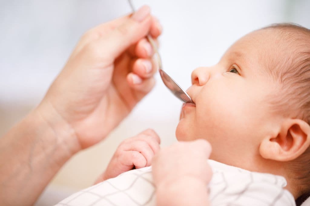 Niño con fenilcetonuria alimentado con cuchara